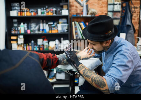 Tätowierer Tätowierung auf der Haut des Auftraggebers zeichnen Stockfoto