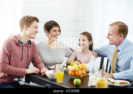 Glücklich Familienmitglieder einander durch Tabelle betrachtend Stockfoto