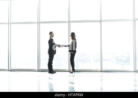 Junges Unternehmen Partner Handshake nach Vereinbarung gegen große Panoramafenster machen. Stockfoto