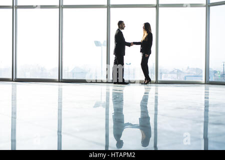 Junges Unternehmen Partner Handshake nach Vereinbarung gegen große Panoramafenster machen. Stockfoto