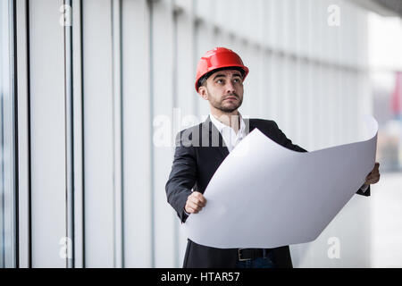 Porträt einer Architekten-Builder Lageplan des Gebäudes, ernst Ingenieur arbeiten mit Dokumenten auf Baustelle zu studieren. Stockfoto