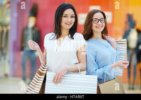 Junge freundliche Shopper mit paperbags Stockfoto