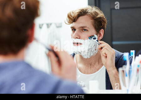 Attraktiver Mann rasieren Bart im Badezimmer Stockfoto