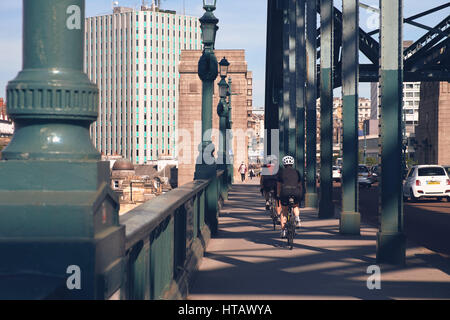 NEWCASTLE UPON TYNE, ENGLAND, UK - 13. August 2015: Radfahrer über die Tyne-Brücke über den Fluss Tyne in Newcastle. Stockfoto