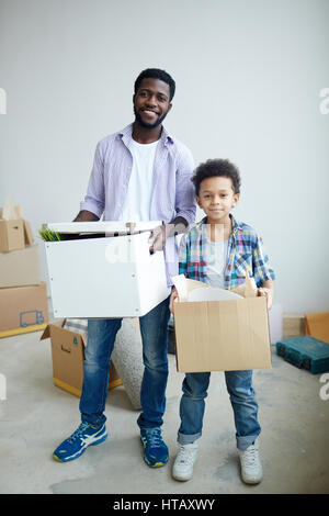 Familie von Vater und Sohn halten Boxen Stockfoto