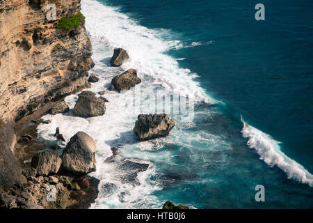 Meereswellen Absturz auf den riesigen Felsen am Strand an einem sonnigen Tag. Bali Indonesien Stockfoto