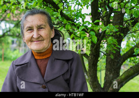 Schöne 80plus-jährigen Senior Frau posiert für ein Portrait in Ihrem Garten. Stockfoto