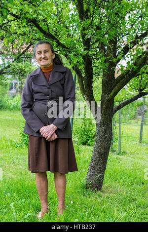 Schöne 80plus-jährigen Senior Frau posiert für ein Portrait in Ihrem Garten. Stockfoto