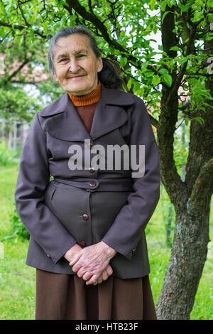 Schöne 80plus-jährigen Senior Frau posiert für ein Portrait in Ihrem Garten. Stockfoto