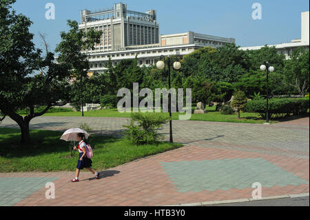 08.08.2012, Pyongyang, Nordkorea - ein Mädchen trägt der junge Pionier einheitliche Spaziergänge auf einem Bürgersteig in Pjöngjang. Stockfoto