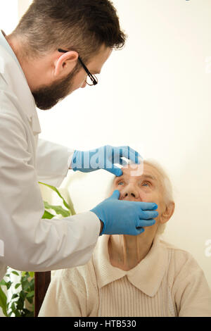 Der Arzt untersucht die Augen, Bindehaut sehr alte Frau Doktor Geriater während des Tests. Stockfoto