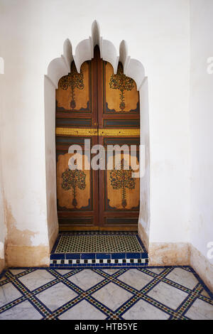 Berber Arabesken bemalte Holztür und Zellige Fliesenboden. Die Petite Gericht, Bahia-Palast, Marrakesch, Marokko Stockfoto