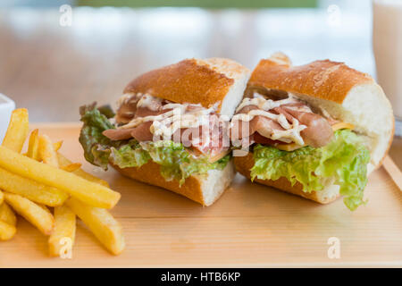 Big Sandwich mit Schinken, Käse, Gemüse und Pommes frites Stockfoto