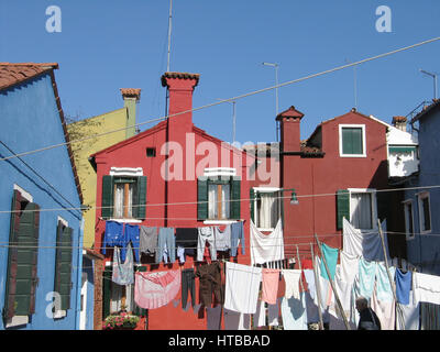 Farbenfrohe Häuser und Wäscheleinen schaffen eine lebendige Atmosphäre in Burano an einem sonnigen Tag. Venedig. Italien Stockfoto