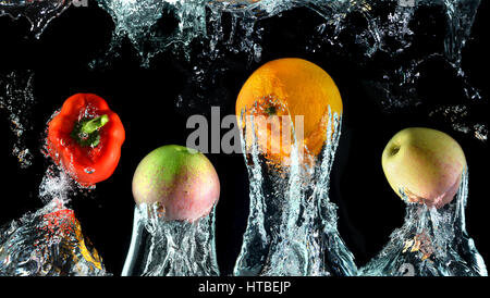 Spritzwasser mit Droping Orangen, Paprika und Äpfeln in der Kunst gemischt im Studio technische Geschwindigkeit und Beleuchtung. Stockfoto