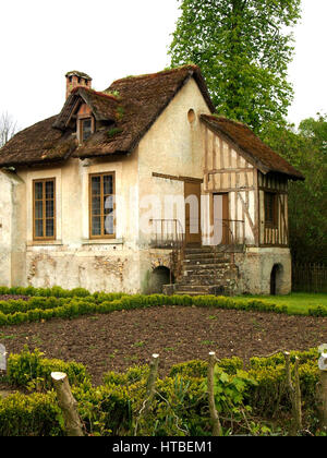 Ein traditioneller französischer Häuschen mit kleinem Garten und einem Strohdach. Stockfoto