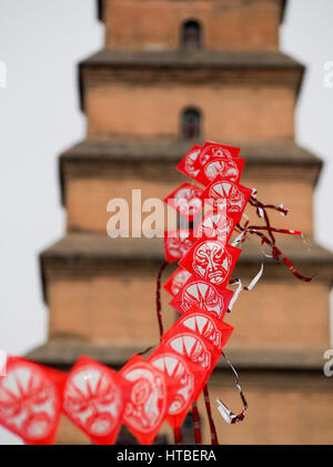 Reihe von chinesischen Rotmilane mit Pagode im Hintergrund. Stockfoto