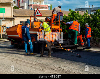 Bari, Italien - 20. April 2016: Arbeiter auf Anlage Fertiger Maschine während Straße Straße Reparatur arbeiten Stockfoto