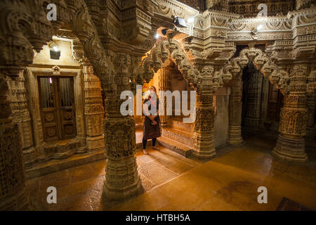 Eine Frau schaut erstaunlichen Steinbildhauen innerhalb der Jain-Tempel in Jaisalmer Fort, Jaisalmer, Rajashan, Indien. Stockfoto