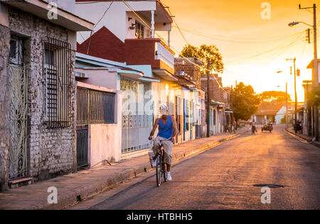 Camagüey, Kuba am 2. Januar 2016: kubanische Mann mit seinem Fahrrad durch eine Straße in der Karibik Altstadt Zentrum von Camagüey bei Sonnenuntergang Stockfoto