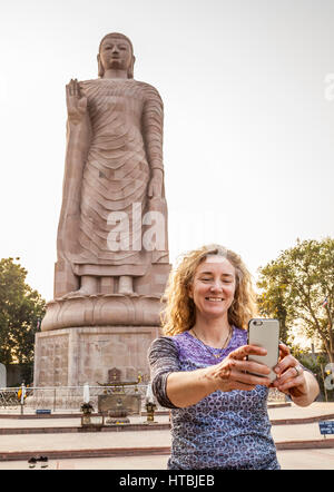 Eine Frau, die ein Selbstportrait von sich selbst vor Thai Buddha Vihar in Sarnath, Indien. Stockfoto