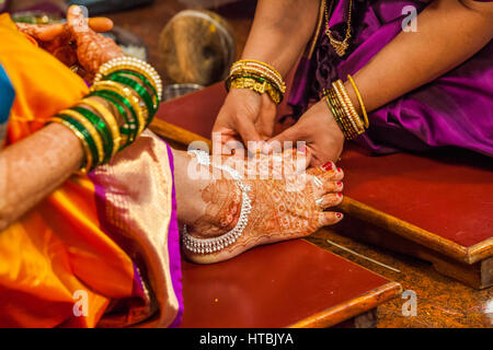Platzieren Ringe an den Zehen der Braut in einer Hindu-Hochzeit, Pune, Indien. Stockfoto