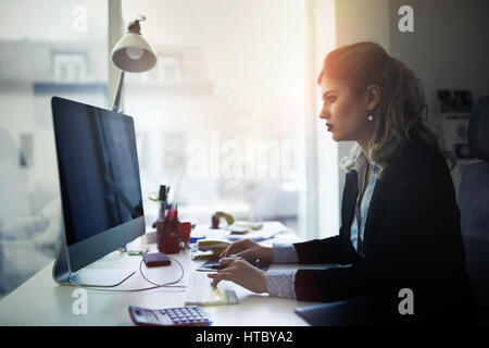 Überarbeitete Geschäftsfrau im Büro spät arbeiten Stockfoto