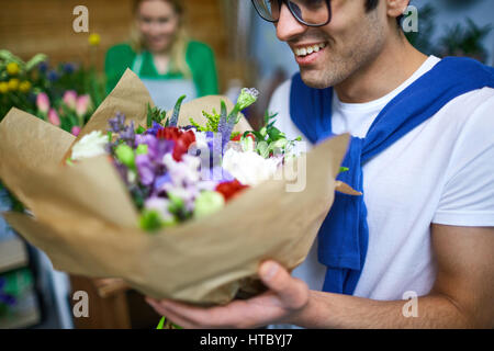 Kerl duftender Blumenstrauß in Florist Shop Stockfoto