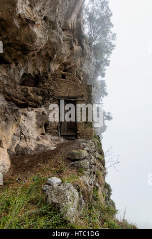 Tor in einer Klippe Wohnung mit Rollen im Nebel Stockfoto