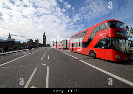 Eine Linie von sechs roten New Routemaster London Bussen auf der Westminster Bridge, London, Großbritannien. Parlament Stockfoto