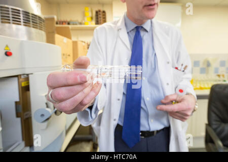 Chris Walne, Laborleiter, bei der Goldschmiede Unternehmen Assay Office, führt eine Reihe von chemischen Tests auf Münzen und Metalle. London, UK. Stockfoto