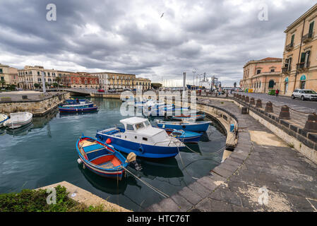 Lokale Fischer Boote am Yachthafen in Syrakus Stadt, südöstlich Ecke der Insel Sizilien, Italien. Santa Lucia-Brücke im Hintergrund Stockfoto