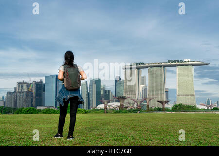 Asiatische Frau Reisenden in Singapur Stadt betrachten mit Rucksack. Solo-Frau Reisender Backpacker in Singapur. Stockfoto