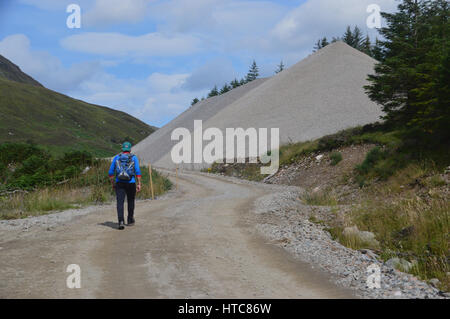 Eine einsame männliche Hillwalker in Gleann Cia-Aig zu Fuß durch Constuction Site, um die schottischen Berge Corbett Meall Na h-Eilde in den schottischen Highlands. Stockfoto