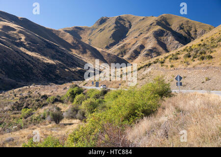 Lindis Tal, Otago, Neuseeland. Auto Richtung Norden durch die dramatische Berglandschaft entlang State Highway 8 Richtung Lindis Pass. Stockfoto