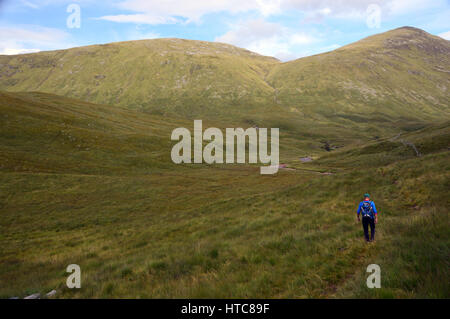 Ein einsamer Mann Hillwalker im Gleann Cia-Aig zu Fuß in Richtung Meall ein Tagraidh & der schottischen Berge Corbett Meall Na h-Eilde in den schottischen Highlands. Stockfoto