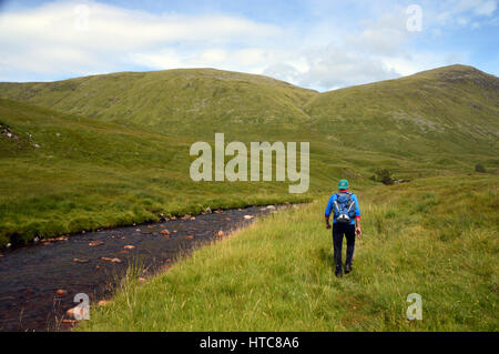 Ein einsamer Mann Hillwalker im Gleann Cia-Aig zu Fuß in Richtung Meall ein Tagraidh & der schottischen Berge Corbett Meall Na h-Eilde in den schottischen Highlands. Stockfoto