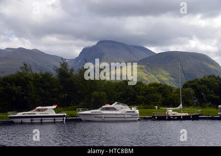 Sportboote und der Munros Anoach Mor, Carn Mor Dearg & Ben Nevis aus den Caladonian Canal in der Nähe von Fort William in den schottischen Highlands. Stockfoto