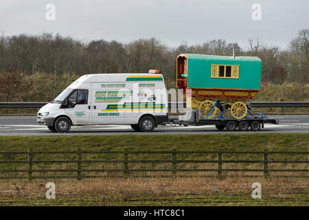 Ford Transit van (mit Anhänger) ist eine traditionelle Roma Bowtop Karawane (Vardo) Abschleppen, unterwegs auf der A1 Autobahn - England, GB, UK. Stockfoto