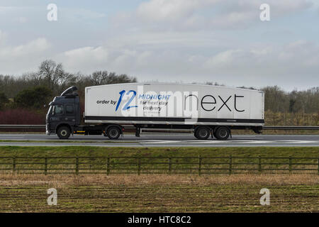 Transport und Transport - Gelenkwagen, Schwerlastwagen (HGV) mit Next Logo auf der Straße - AUTOBAHN A1, England, GB, Großbritannien. Stockfoto