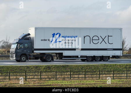 Transport und Transport - Gelenkwagen, Schwerlastwagen (HGV) mit Next Logo auf der Straße - AUTOBAHN A1, England, GB, Großbritannien. Stockfoto