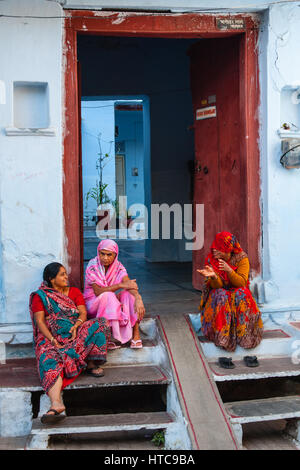 Frauen Holzveranda und sprechen durch eine Tür in Udaipur Stockfoto