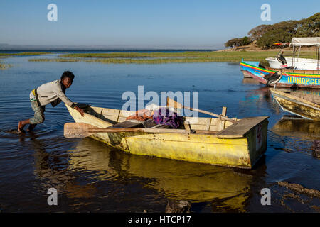 Ein einheimischer Fischer kehrt in den "Fischmarkt" an den Ufern des Sees Awassa im Morgengrauen nach Fischen alle Nacht auf dem See, See Awassa, Äthiopien Stockfoto