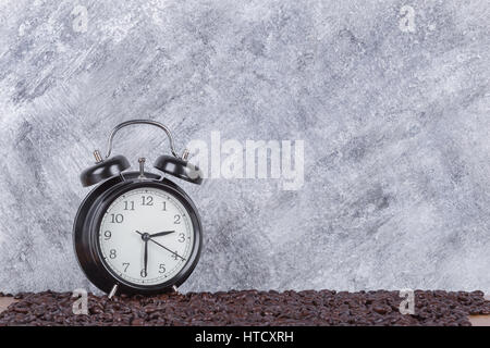 Vintage Uhr und Kaffeebohnen (Kaffee-Zeit-Konzept) mit Betonmauer Hintergrund Stockfoto