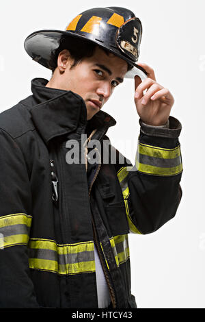 Feuerwehrmann Trinkgeld seinen Hut Stockfoto