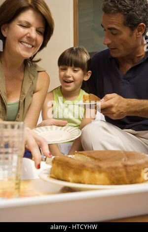 Mädchen mit Torte mit Großeltern Stockfoto