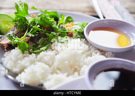 Vietnamesische gebrochen Reis oder com Tam mit gebratene Hähnchenschenkel, Schweinefleisch und Kräutern Stockfoto
