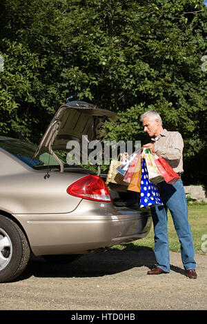 Mann, Einkaufstaschen in Auto Stockfoto