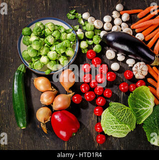 Frisches Biogemüse auf dunklen Holztisch. Ansicht von oben Stockfoto