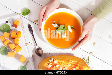 Frau Hände halten Kürbis Suppe. Ansicht von oben Stockfoto